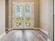 Elegant entryway featuring a decorative glass double-door, wood-look tile flooring, and neutral paint at 170 Antilla Dr, Rotonda West, FL 33947