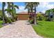 Attractive home with a paver driveway, well-maintained landscaping, and a verdant lawn, creating a welcoming facade at 170 Antilla Dr, Rotonda West, FL 33947