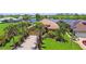 Beautifully landscaped home overlooking a tranquil lake, featuring a paver driveway and lush tropical surroundings at 170 Antilla Dr, Rotonda West, FL 33947