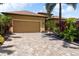 Charming single-story home showcasing a tan exterior, paver driveway, and well-maintained landscaping at 170 Antilla Dr, Rotonda West, FL 33947