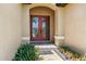 Inviting front entryway features a double red door, brick pavers, and colorful landscaping at 170 Antilla Dr, Rotonda West, FL 33947