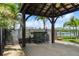 A wooden gazebo on a wood deck features seating and a fenced yard overlooking a serene lake at 170 Antilla Dr, Rotonda West, FL 33947