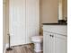 This half bathroom features a toilet, a small cabinet, a towel rack and wood-look floors at 170 Antilla Dr, Rotonda West, FL 33947