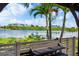Enjoy tranquil lake views from the patio, featuring palm trees, a fence and outdoor seating at 170 Antilla Dr, Rotonda West, FL 33947