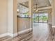Open-concept living room with wood-look tile flooring, neutral walls, and water view through sliding glass doors at 170 Antilla Dr, Rotonda West, FL 33947