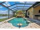Inviting pool area with rock waterfall feature, lush landscaping, and clear blue water at 170 Antilla Dr, Rotonda West, FL 33947