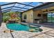 Outdoor pool with spa and waterfall feature under screened enclosure overlooking the water at 170 Antilla Dr, Rotonda West, FL 33947