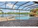 Screened-in pool area featuring tropical landscaping and stunning lake views at 170 Antilla Dr, Rotonda West, FL 33947
