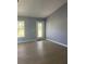 Bright living room featuring light blue walls, wood floors, and an exit door at 1708 Blue Lake Cir, Punta Gorda, FL 33983