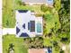 An overhead aerial view shows solar panels on the roof and a screened-in pool surrounded by green landscaping at 18147 Brazil Ave, Port Charlotte, FL 33948