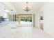 Bright dining area featuring tile floors, a chandelier, and views of the lanai and sparkling pool at 18147 Brazil Ave, Port Charlotte, FL 33948