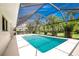 Sparkling screened pool surrounded by lush landscaping, perfect for relaxation and recreation at 18147 Brazil Ave, Port Charlotte, FL 33948