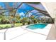 Beautiful screened pool with ample deck space, set against a backdrop of tropical foliage at 18147 Brazil Ave, Port Charlotte, FL 33948