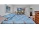 Comfortable bedroom with a patterned blue quilt and sliding glass doors at 19505 Quesada Ave # Tt101, Port Charlotte, FL 33948