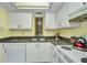 Kitchen features white appliances and cabinets, complemented by dark countertops at 19505 Quesada Ave # Tt101, Port Charlotte, FL 33948