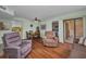Inviting living room featuring wood floors, dining area, bedroom access, and sliding door at 19505 Quesada Ave # Tt101, Port Charlotte, FL 33948