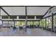 A community meeting room filled with tables and chairs, ceiling fans, a book shelf, and a wall of windows at 19505 Quesada Ave # Tt101, Port Charlotte, FL 33948