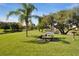 Beautiful park featuring a picnic area and grill, mature landscaping, and scenic pond views at 19505 Quesada Ave # Tt101, Port Charlotte, FL 33948