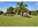 Beautiful park area, featuring a picnic table, grill, and pond with a fountain and mature landscaping at 19505 Quesada Ave # Tt101, Port Charlotte, FL 33948