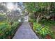 Landscaped walkway with lush greenery leading to a gated entrance, enhancing curb appeal at 19505 Quesada Ave # Tt101, Port Charlotte, FL 33948