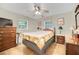 Comfortable bedroom featuring two windows, wood furniture, tile flooring, and a ceiling fan at 2131 Amanda Dr, Sarasota, FL 34232