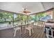 Screened-in patio featuring a ceiling fan, a table, four chairs and a grill at 2131 Amanda Dr, Sarasota, FL 34232