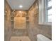 Walk-in shower featuring tiled walls, tiled flooring, shelving and chrome fixtures at 2131 Amanda Dr, Sarasota, FL 34232