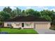 Charming single-story home with a two-car garage, covered porch, and well-manicured lawn at 220 Spring Dr, Rotonda West, FL 33947