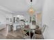 Dining area with modern chandelier and wood-look flooring and adjacent kitchen at 23141 Corvin Ave, Port Charlotte, FL 33954
