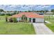 Charming home featuring lush landscaping, a vibrant tile roof, and a well-manicured lawn at 23141 Corvin Ave, Port Charlotte, FL 33954