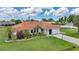 Charming home featuring lush landscaping, a vibrant tile roof, and a well-manicured lawn at 23141 Corvin Ave, Port Charlotte, FL 33954