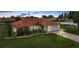 Charming home featuring lush landscaping, a vibrant tile roof, and a well-manicured lawn at 23141 Corvin Ave, Port Charlotte, FL 33954