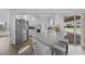 Open kitchen features stainless steel refrigerator, counter seating and sliding door access to screened lanai at 23141 Corvin Ave, Port Charlotte, FL 33954