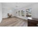 Bright, minimalist living room featuring wood-look flooring and large windows at 23141 Corvin Ave, Port Charlotte, FL 33954