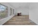 Spacious living room featuring wood-look flooring, natural light, and minimalist decor at 23141 Corvin Ave, Port Charlotte, FL 33954