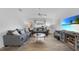 Bright living room featuring contemporary furnishings, wood-look flooring, and a modern ceiling fan at 23141 Corvin Ave, Port Charlotte, FL 33954