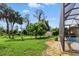 A lovely backyard featuring a lush lawn, mature trees, and a charming screened lanai with pool at 2329 Como St, Port Charlotte, FL 33948