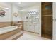 Elegant bathroom featuring a large soaking tub, tiled shower, and vanity with a large mirror at 2329 Como St, Port Charlotte, FL 33948