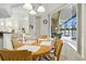 Sunlit dining area showcases a wood table, chairs, and large windows overlooking a screened pool at 2329 Como St, Port Charlotte, FL 33948