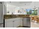 Bright kitchen features stainless steel appliances, stone countertops, and an adjacent dining area with pool views at 2329 Como St, Port Charlotte, FL 33948
