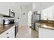 Modern kitchen boasts granite countertops, stainless steel appliances, and ceramic tile flooring at 2329 Como St, Port Charlotte, FL 33948