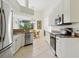 Modern kitchen featuring white cabinets, granite countertops, stainless steel appliances, and a breakfast nook at 2329 Como St, Port Charlotte, FL 33948
