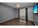 Cozy bedroom featuring a ceiling fan, a large window, and dark wood flooring at 2437 Harbor Blvd # 114, Port Charlotte, FL 33952