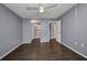 Open bedroom featuring wood floors, ceiling fan, and entryways to other rooms at 2437 Harbor Blvd # 114, Port Charlotte, FL 33952