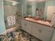 Light and airy bathroom with double sink vanity and a glass enclosed shower with shelves at 25228 E Lenox Cir, Punta Gorda, FL 33950