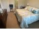 Cozy bedroom featuring a large bed, wood dresser, and an attached bathroom with glass enclosed shower at 25228 E Lenox Cir, Punta Gorda, FL 33950