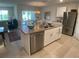 Bright kitchen featuring stainless steel appliances, an island with sink and dishwasher and an adjacent dining area at 25228 E Lenox Cir, Punta Gorda, FL 33950