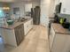 Bright kitchen featuring stainless steel appliances, tile floors, white cabinets and an island with sink and dishwasher at 25228 E Lenox Cir, Punta Gorda, FL 33950