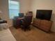 A bright office offers space for both work and relaxation with a desk, TV, and a comfortable sofa at 25228 E Lenox Cir, Punta Gorda, FL 33950