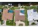 Aerial view of a property with a swimming pool, manicured lawns, a waterfront canal and a brick driveway at 2814 La Mancha Ct, Punta Gorda, FL 33950